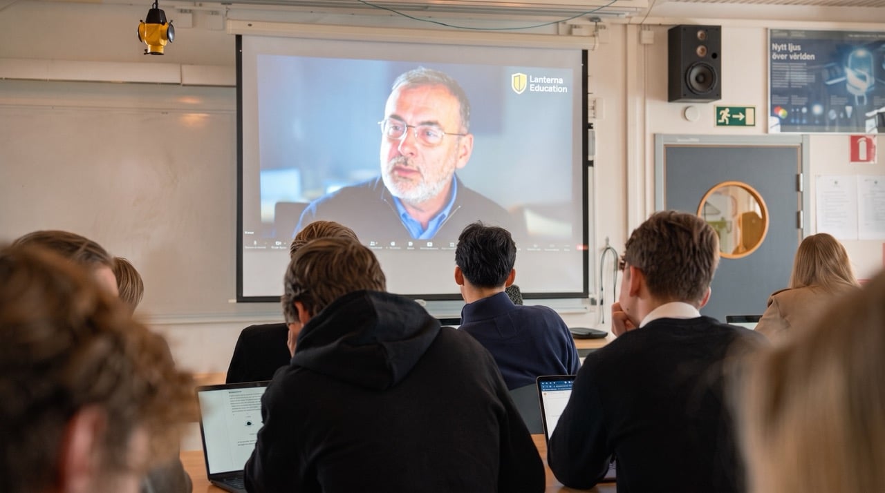 A teacher leading a live online IB lesson from his study
